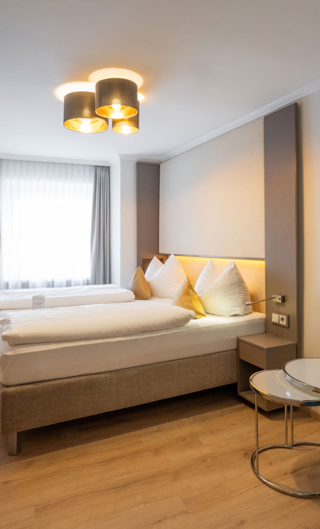Beige Kissen und Lampe vor braunen Vorhängen